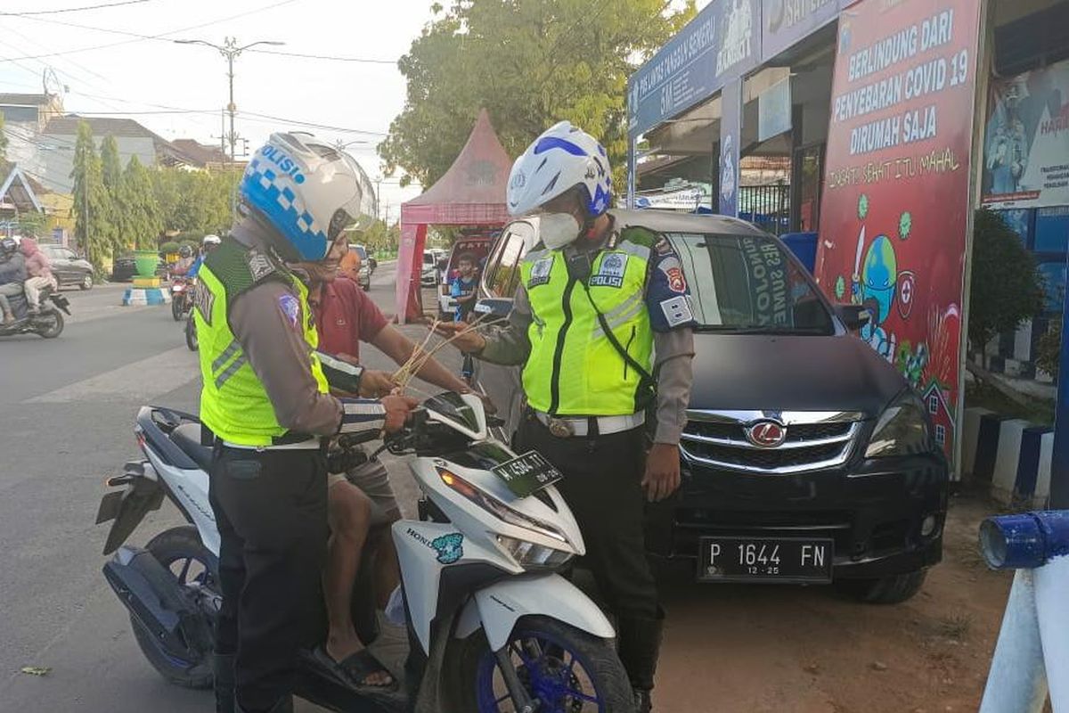 Petugas Satlantas Polres Sumenep memberikan tanda janur kuning terhadap pengendara yang melanggar lalu lintas di Sumenep, Senin (25/4/2022). 