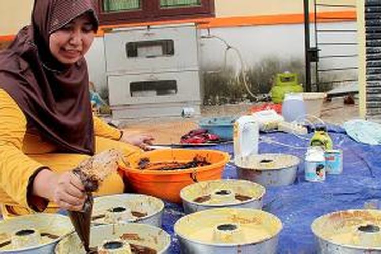 Pemilik usaha rumahan kue, Nyayu Helen Kurnia (30), tengah memasak makanan-makanan lebaran khas Palembang, seperti maksuba, kue delapan jam, engkak, dan kojo, di rumahnya di Palembang, Sumatera Selatan, Selasa (14/7/2015). Untuk menyajikan makanan-makanan tradisional ini, Nyayu mengerahkan panggong atau juru masak makanan khas Palembang yang telah menjadi juru masak secara turun-temurun.