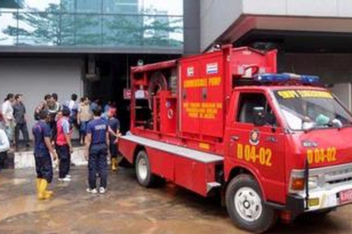 Petugas berusaha mengevakuasi korban yang diduga masih terjebak di dalam basement Gedung UOB Plaza, Jakarta, Jumat (18/1/2013). Hingga saat ini petugas masih berusaha mengeringkan air yang merendam basement gedung tersebut.