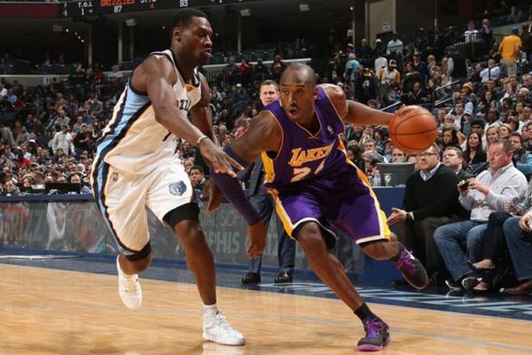 Pebasket Los Angeles Lakers, Kobe Bryant (kanan) mencoba melewati pemain Memphis Grizzlies pada laga lanjutan kompetisi NBA di FedExForum in Memphis, Tennessee, Selasa (17/12/2013).