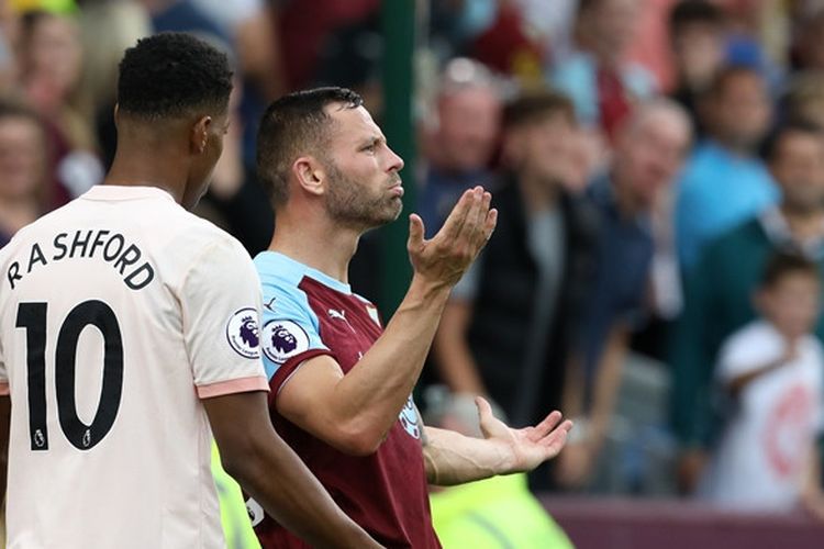 Penyerang Manchester United, Marcus Rashford (kiri), bersitegang dengan bek Burnley, Phil Bardsley, dalam laga Liga Inggris di Stadion Turf Moor, Burnley pada 2 September 2018.
