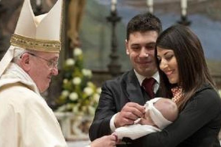 Paus Fransiskus membaptis salah satu dari 32 bayi dalam sebuah misa di Kapal Sistine di Vatikan, Minggu (12/1/2014).