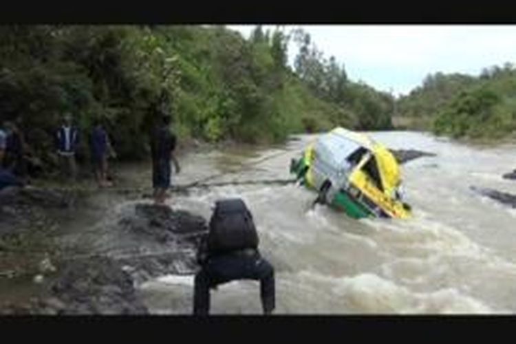 Bangkai mobil ambulance yang teronggok di dalam sungai.
