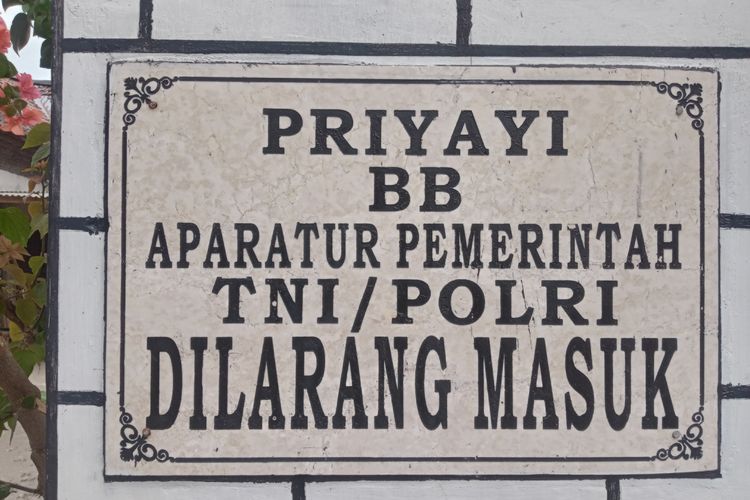 Plakat larangan masuknya pegawai yang terpasang di gapura masuk Dusun Setono, Desa Tales, Kecamatan Ngadiluwih.