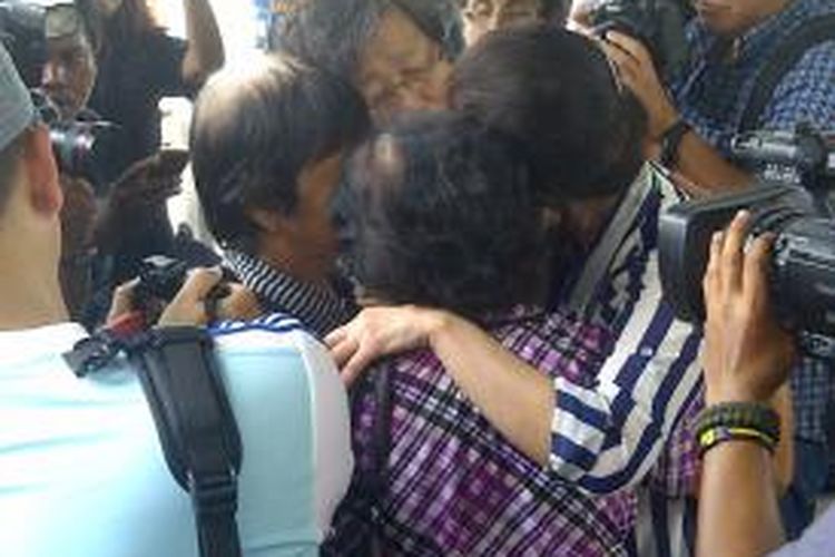 Keluarga penumpang QZ8501 menangis berpelukan karena belum ada kabar nasib keluarganya.