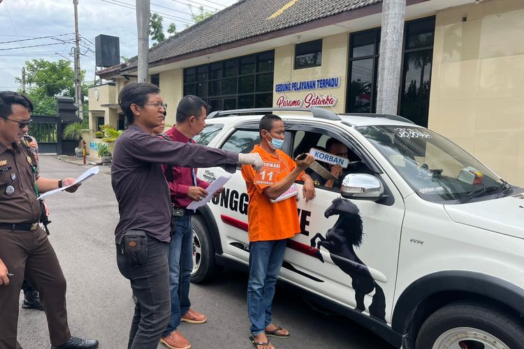 Tersangka ST saat memeragakan aksi pembunuhan terhadap korban SU. Rekonstruksi kasus pembunuhan ini berlangsung di Lapangan Apel Kepolisian Resor Nganjuk, Senin (9/12/2024)