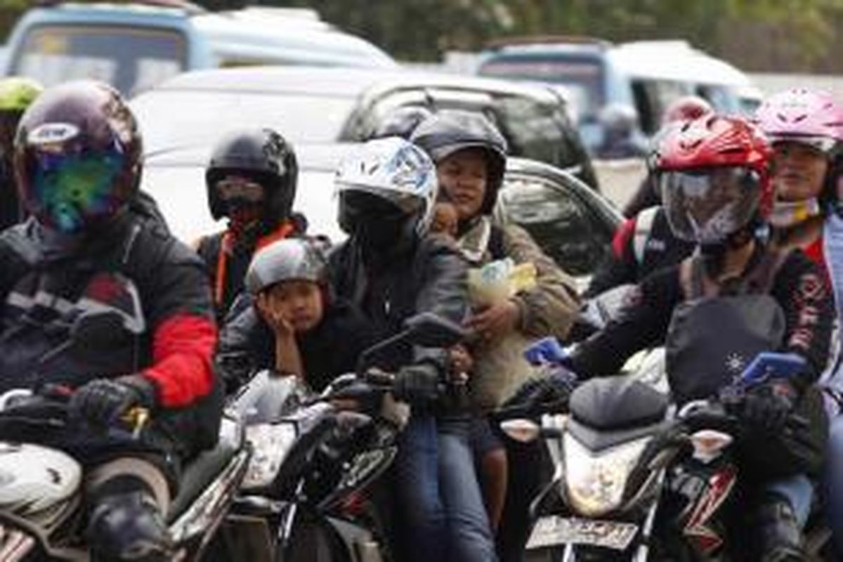Pemudik bersepeda motor membawa anaknya, saat melintasi ruas Jalan Kalimalang, Bekasi, Jawa Barat, Selasa (14/7/2015). Arus pemudik bersepeda motor diperkirakan akan melonjak mulai malam ini hingga satu hari sebelum Lebaran Idul Fitri 1436 H.
