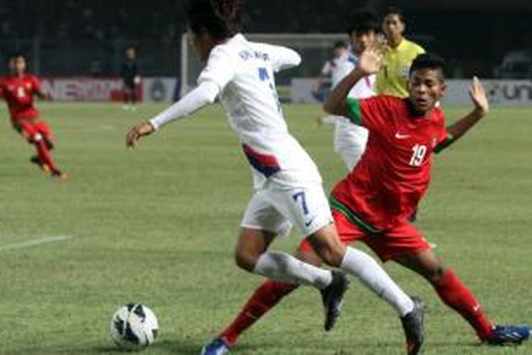 Pemain Indonesia Ilham Udin Armayn (kanan) berjibaku dengan pemain Korea Selatan dalam pertandingan Piala AFC U-19 di Stadion Utama Gelora Bung Karno, Jakarta, Sabtu (12/10/2013). Indonesia memiliki nilai yang sama dengan Korea Selatan dalam babak Penyisihan Piala AFC U-19 Grup G.