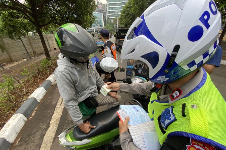 Pengemudi ojol bernama Riyadi merasa kecewa lantaran terkena tilang uji emisi di Kembangan, Jakarta Barat, Rabu (1/11/2023). 