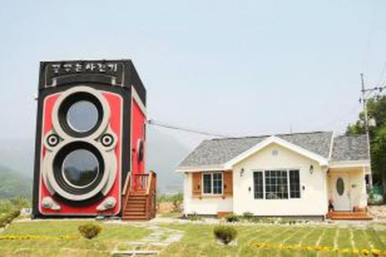 Sebuah daerah pinggir kota di Korea Selatan menjadi rumah bagi kafe unik berbentuk kamera vintage. Kafe bernama Dreamy Camera Cafe ini sengaja dibentuk menyerupai kamera lensa ganda Rolleiflex Vintage.
