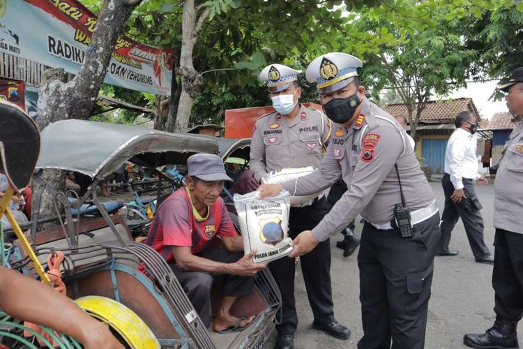 Anggota Polres Kebumen membagikan bansoa beras kepada para tukang becak di Kebumen, Jawa Tengah, Senin (12/9/2022).