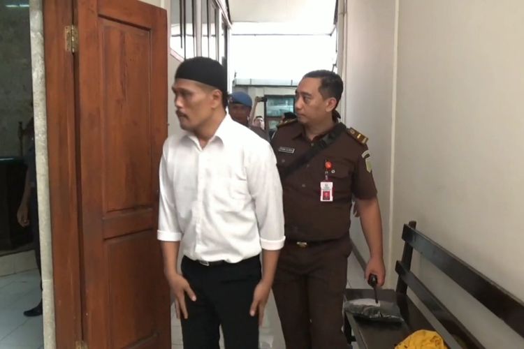 Terdakwa pelaku pembunuhan pasangan suami istri di Tulungagung Jawa Timur, memasuki ruang sidang, Rabu (28/02/2024). Ia divonis 14 tahun penjara.