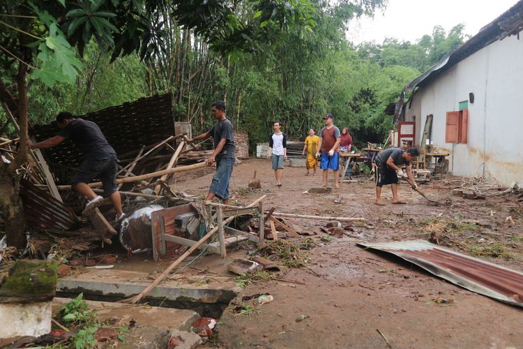 Warga Desa Banjaragung, Kecamatan Bareng, Kabupaten Jombang, Jawa Timur, membersihkan sampah sisa banjir serta memperbaiki rumahnya yang rusak akibat bandang, Selasa (2/2/2021).