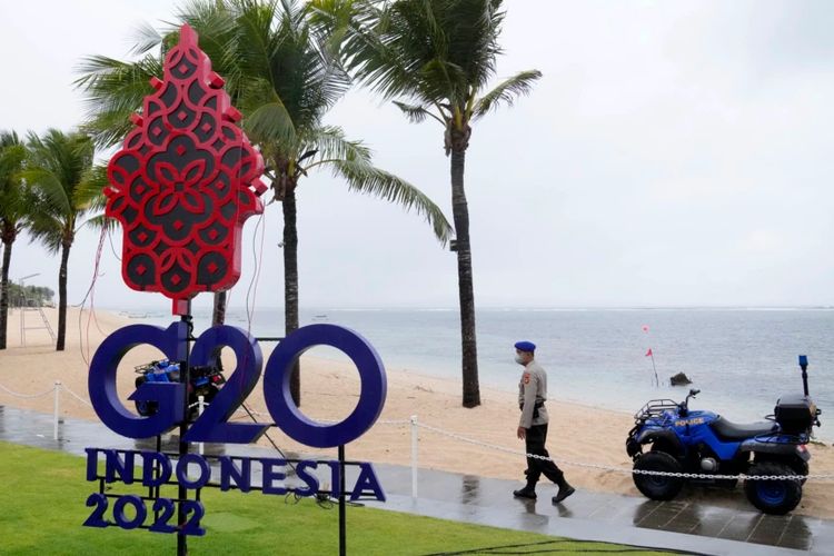 Seorang polisi berjalan melewati tanda G20 di Nusa Dua, Bali, 7 Juli 2022. Ketegangan di antara para anggota G20 menimbulkan kekhwatiran bahwa pelaksanaa KTT kali ini tidak akan menghasilkan komunike bersama.