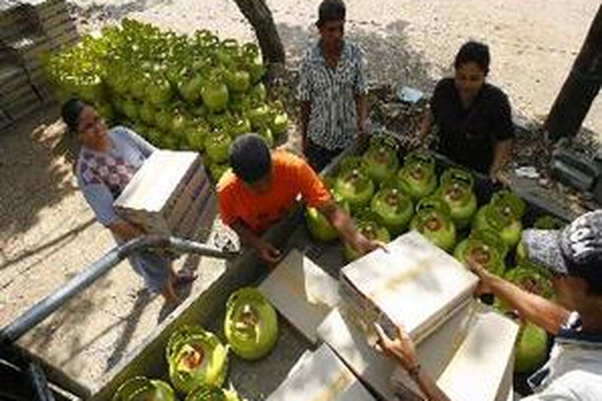 Warga mengangkat kompor dan tabung gas elpiji tiga kilogram ke atas mobil terbuka untuk dibagi di RW 02 Kelurahan Makasar, Jakarta Timur.