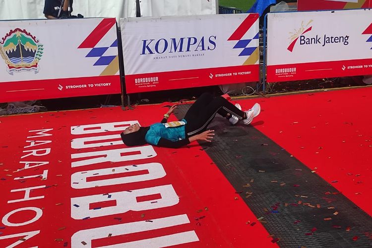 Yulianti Utari terkapar usai memasuki garis finis pada lomba Women's Elite Race Borobudur Marathon 2022 yang digelar di Taman Lumbini, Candi Borobudur, Magelang, Jawa Tengah, pada Sabtu (12/11/2022). Yulianti Utari finis di urutan kedua dan berhak membawa pulang hadiah Rp 30 Juta.
