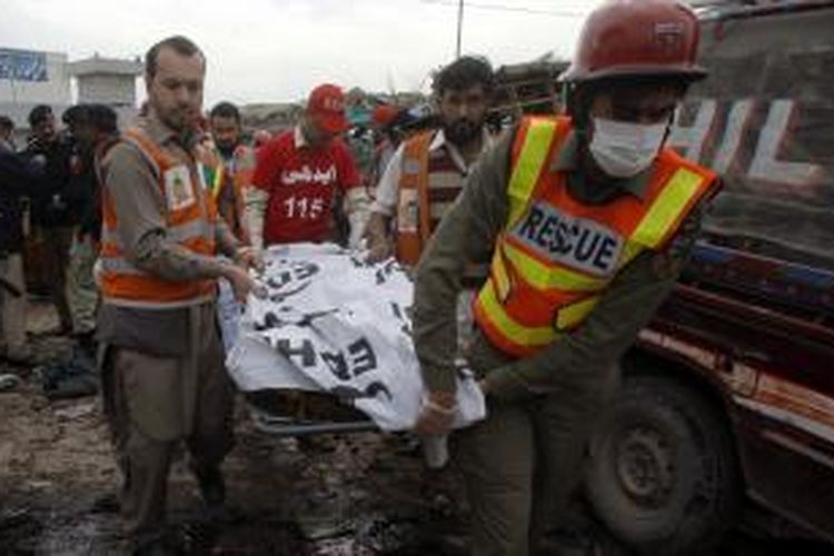 Tim penyelamat sedang mengangkut salah seorang korban bom bunuh diri di Peshawar, Pakistan yang menewaskan sembilan orang. 