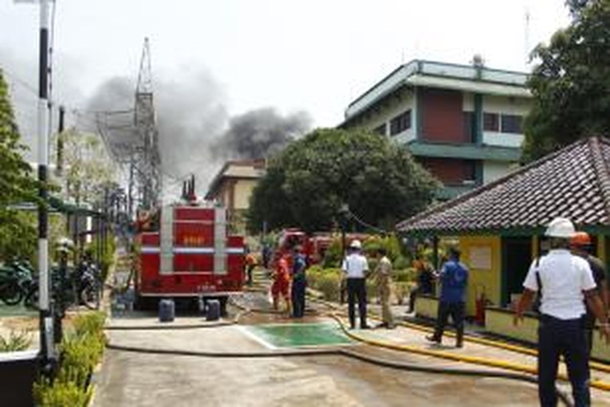 Petugas pemadam kebakaran berusaha memadamkan api yang melahap Gardu Induk PLN, di Kembangan, Jakarta Barat, Rabu (2/9/2015).