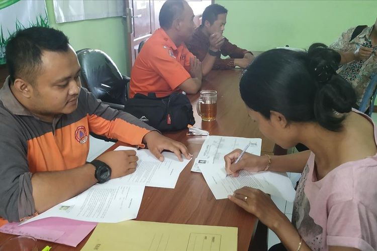 Seorang penyintas bencana menandatangani surat pernyataan di kantor Desa Kertaangsana, Nyalindung, Sukabumi,Jawa Barat, Kamis (11/7/2019).