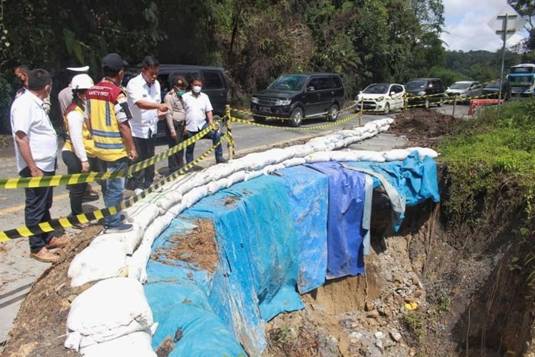 Bupati Simalungun Radiapoh Hasiholan Sinaga meninjau jalan longsor penghubung Pematangsiantar-Parapat di Nagori Parmonangan Kecamatan Dolok Panribuan Kabupaten Simalungun, Sumut, Selasa (19/4/2022).