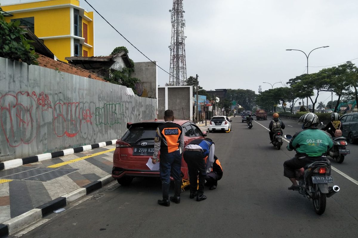 Dishub Kota Depok menggembok roda kendaraan mobil yang terparkir liar di Kawasan Tertib Lalu Lintas, di Jalan Margonda Raya, Depok, Sabtu (16/4/2022).
