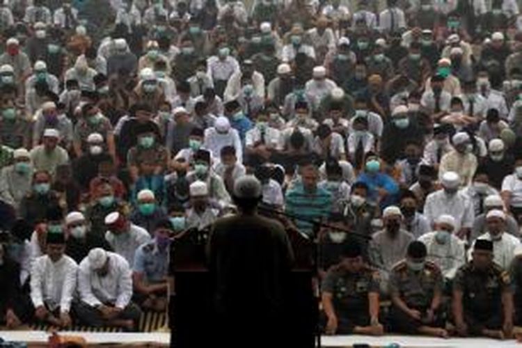 Umat muslim mengenakan masker usai shalat Istisqa di halaman Masjid Agung An Nur Pekanbaru, Senin (7/9/2015). Shalat minta turun hujan ini di dilakukan saat Riau mengalami kemarau serta diselimuti oleh kabut asap tebal dampak kebakaran hutan dan lahan.