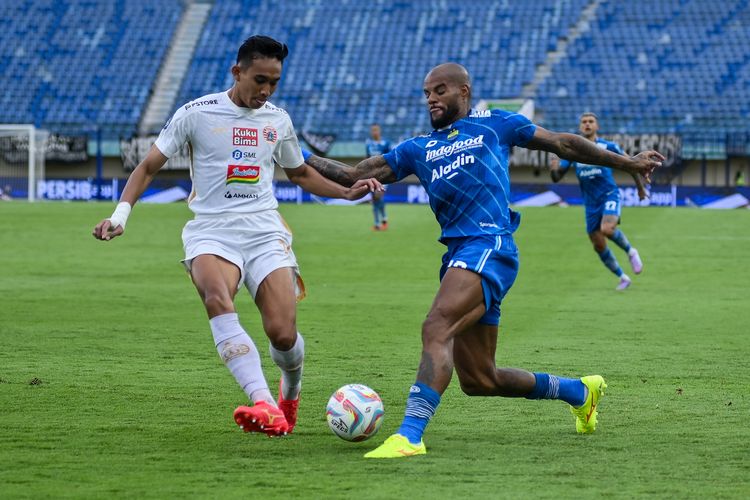 Rizky Ridho bek Persija Jakarta (putih), coba mengadang usaha David da Silva untuk masuk ke kotak penalti dalam pertandingan pekan ke-28 Liga 1 2023-2024 antara Persib vs Persija, Sabtu (9/3/2024) di Si Jalak Harupat Soreang, Kabupaten Bandung. 