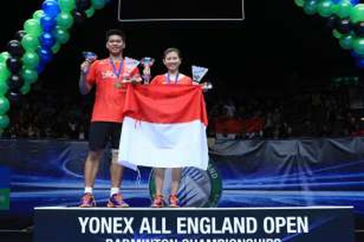 Pasangan ganda campuran Indonesia, Praveen Jordan/Debby Susanto, berpose dengan memegang trofi juara All England dan bendera Merah Putih setelah memenangi laga final melawan Joachim Fischer Nielsen/Christina Pedersen (Denmark) di Barclaycard Arena, Birmingham, Minggu (13/3/2016).