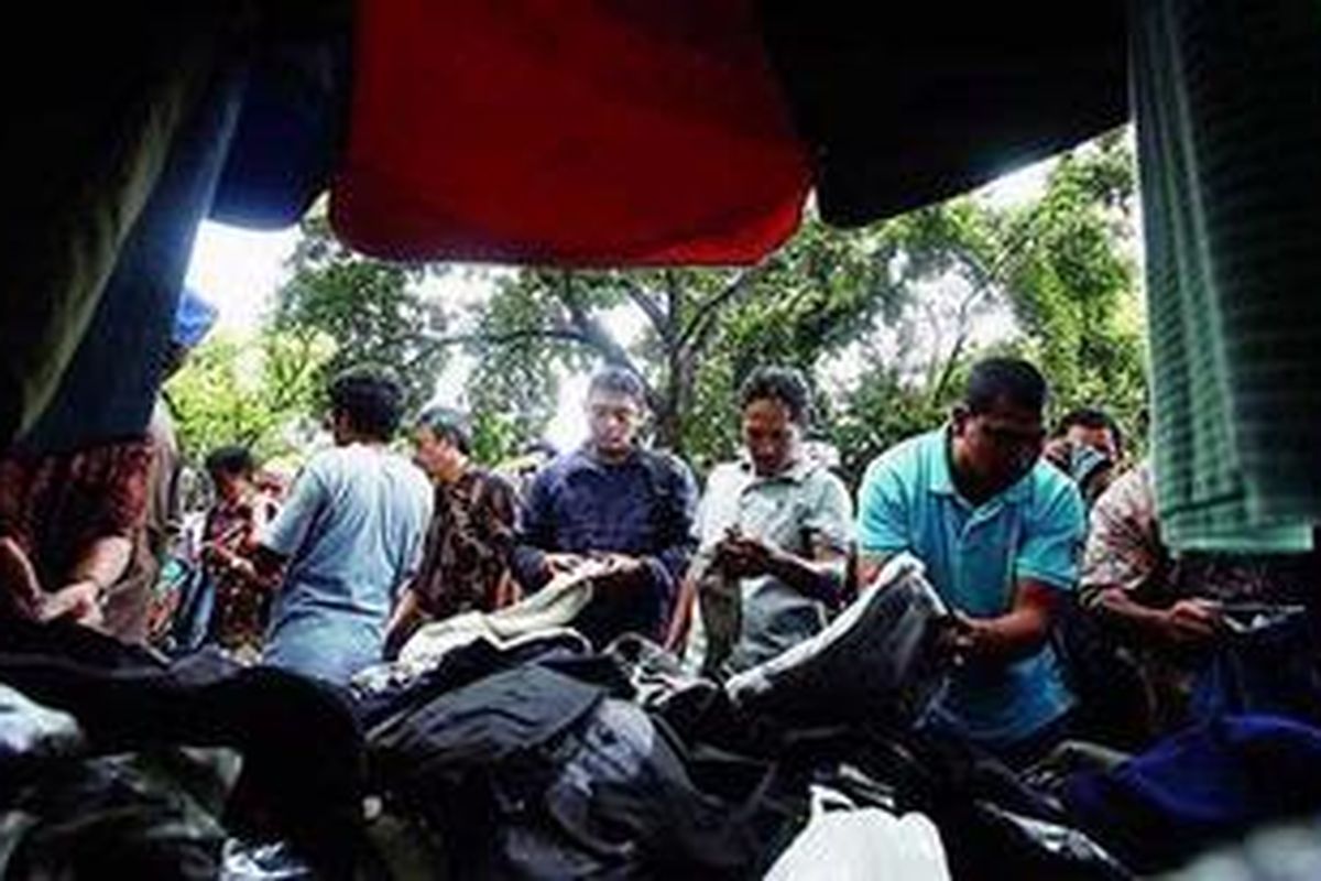 Warga melihat pakaian yang ditawarkan pedagang kaki lima (PKL) di Jalan Sunan Ampel, Blok M, Jakarta Selatan, Jumat (16/3/2012). Lapak PKL yang buka di pinggir jalan pada waktu tertentu dan berpindah-pindah kini marak dijumpai.