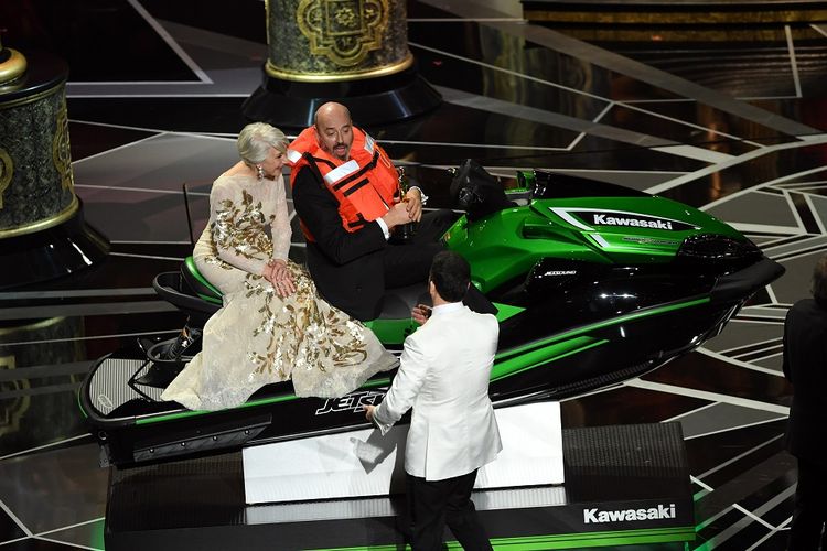 (Dari kiri ke kanan) Aktris Helen Mirren duduk di jetski dengan pemenang Piala Oscar untuk tata busana Mark Bridges di panggung Academy Awards 2018 di Dolby Theatre, Los Angeles, Minggu (4/3/2018). Jetski itu merupakan hadiah dari pembawa acara Jimmy Kimmel (berjas putih) untuk pemenang Oscar dengan pidato tersingkat.