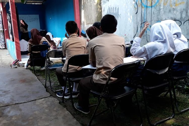 Puluhan siswa SMP TB 911 yang menginduk SMP 1 Cijeruk melakukan kegiatan belajar mengajar (KBM) di halaman rumah menggunakan terpal, milik Cucu Sumiati (39) selaku tenaga pengajar dan relawan pendidikan, Kamis (29/8/2019)