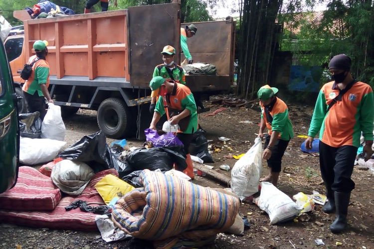 Petugas Suku Dinas Lingkungan Hidup Jakarta Selatan mengangkut sampah pasca-longsor dan banjir dari pemukiman warga Jalan Damai 2,m RT 04/RW 02, Ciganjur, Jagakarsa, Jakarta.