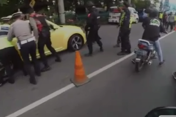Pengendara mobil VW kuning menolak berhenti dan menabrak polisi hingga melarikan diri.