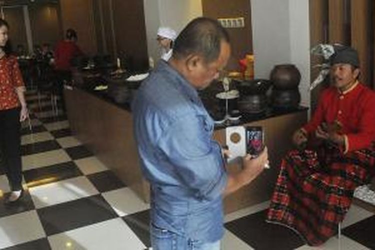 Haeruddin memainkan kecapi dihadapan para tamu yang bersantap pagi di Hotel Santika Makassar, 3 Juli 2015. Kecapi yang luwes beadaptasi dengan beragam bentuk musik modern menarik minat sejumlah hotel di Makassar untuk menyuguhkannya kepada para tamu hotel. 