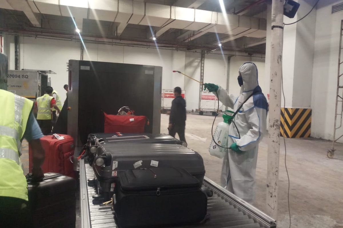 Penyemprotan dengan cairan disinfektan ke bagasi penumpang di area kedatangan internasional Bandara Soekarno-Hatta, Rabu (18/3/2020)