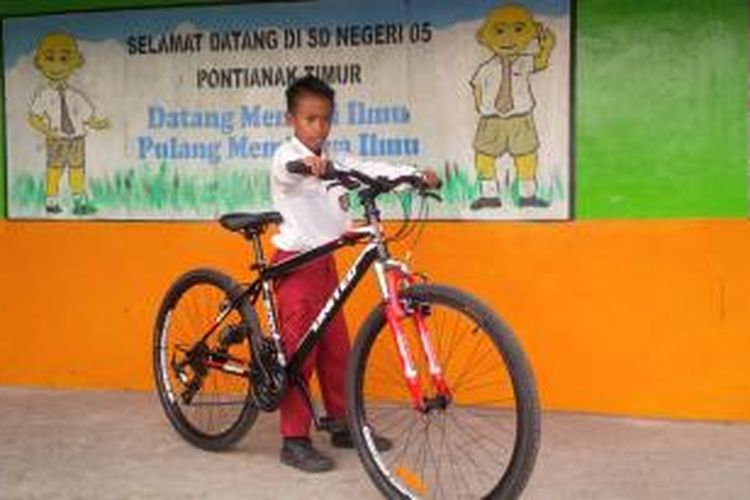 Irfan Hakim alias Ivan berpose bersama sepeda pemberian Presiden Joko Widodo.