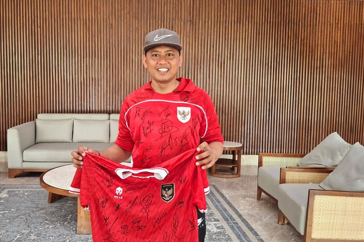 Heri Istiawan (38), suporter tim nasional (timnas) Indonesia, saat memamerkan jersei yang sudah ditandatangani pemain timnas Indonesia di hotel Sanur, Kota Denpasar, Bali, pada Minggu (1/6/2025). KOMPAS.com/ Yohanes Valdi Seriang Ginta