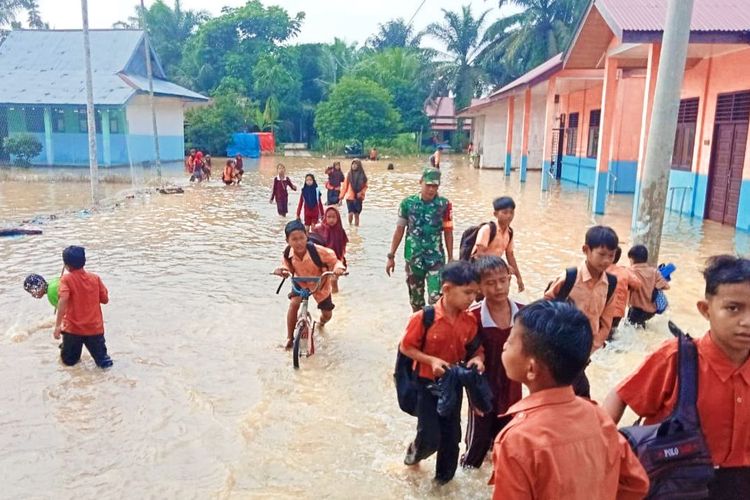 Anggota TNI mengawasi pemulangan para siswa SD karena sekolah mereka terdampak banjir, di Kecamatan Bonai Darussalam, Kabupaten Rokan Hulu, Riau (31/8/2023).