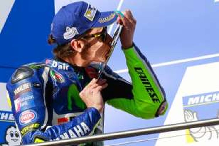 Pebalap Movistar Yamaha asal Italia, Valentino Rossi, mencium trofi hasil finis di urutan kedua pada balapan GP Australia di Sirkuit Phillip Island, Minggu (23/10/2016).