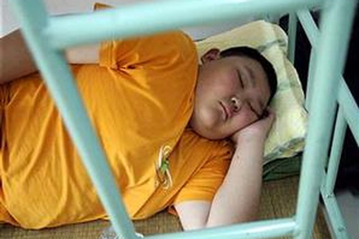 Seorang anak yang mengikuti program pelangsingan tubuh di China sedang tidur siang. Kurang tidur diyakini bisa menyebabkan seseorang mengalami kegemukan.