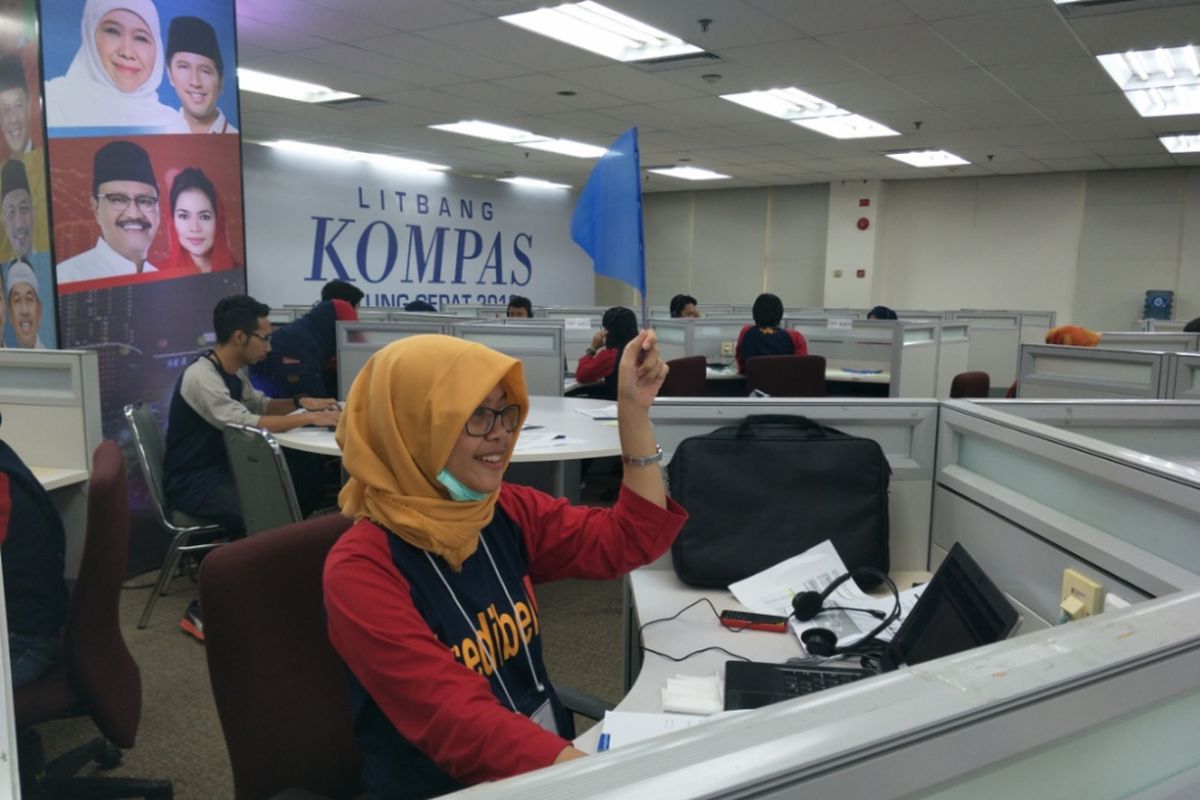 Tim Konfirmator saat mengangkat bendera di ruang Pusat Kendali Litbang Kompas, Rabu (27/6/2018).