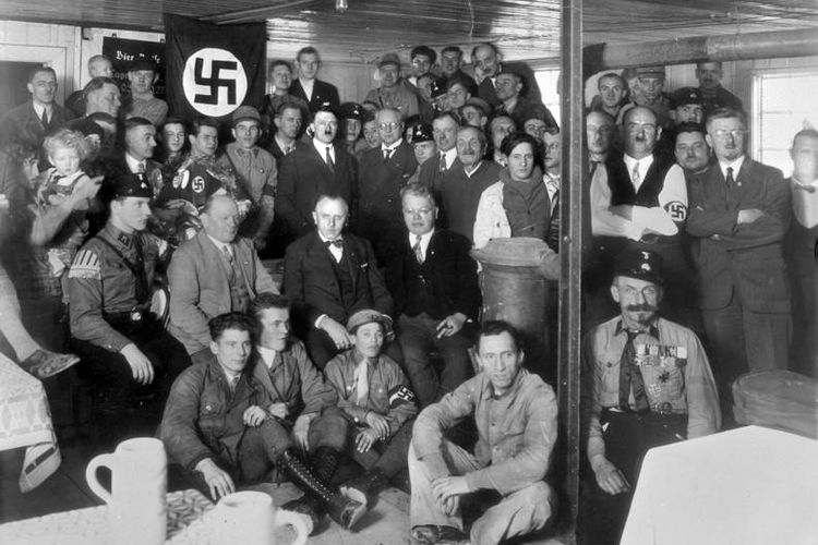 Adolf Hitler bersama anggota Partai Nazi pada 1930.