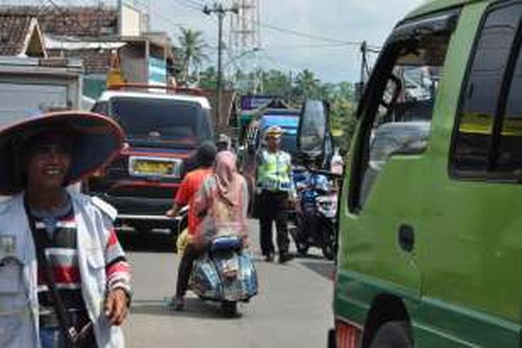 Seorang petugas dari Satlantas Polres Semarang tengah mencairkan keruwetan lalu lintas di Pasar Suruh, Kabupaten Semarang, Rabu (1/6/2016).