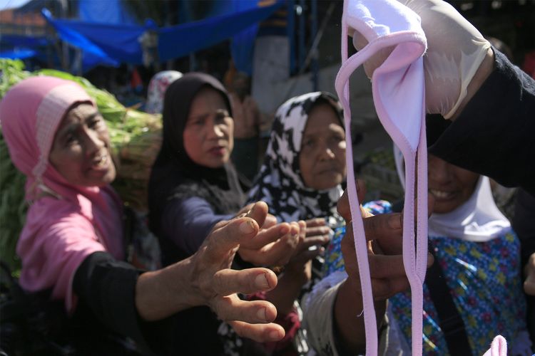 Komunitas etnis tionghoa yang tergabung dalam Yayasan Hakka Aceh membagikan masker dan hand sanitizer kepada pedagang kaki lima dan warga di pasar Peunayong,Kota Banda Aceh. Rabu (08/04/2020). 5000 masker dan hand sanitizer ini dibagikan secara geratif kepada pedagang kaki lima dan warga yang tidak memilki masker saat beraktifitas diluar rumah ini dilakukan sebagi aksi berbagi sesama untuk mencegah penyebaran wabah virus corona di Aceh, seperti himbauan pemerintah masyarakat wajib menggunkan masker saat melakukan aktivitas di luar rumah.