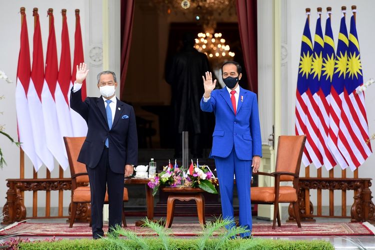 Presiden Joko Widodo (kanan) bersama Perdana Menteri Malaysia Muhyiddin Yassin (kiri) melambaikan tangan di veranda Istana Merdeka, Jakarta, Jumat (5/2/2021). Presiden Joko Widodo menerima kunjungan kenegaraan perdana dari PM Malaysia Muhyiddin Yassin dan kedua pemimpin negara tersebut membahas hubungan bilateral meliputi perlindungan WNI di Malaysia dan sejumlah isu kawasan dan global. ANTARA FOTO/Setpres/Laily Rachev/Handout/sgd/wsj.