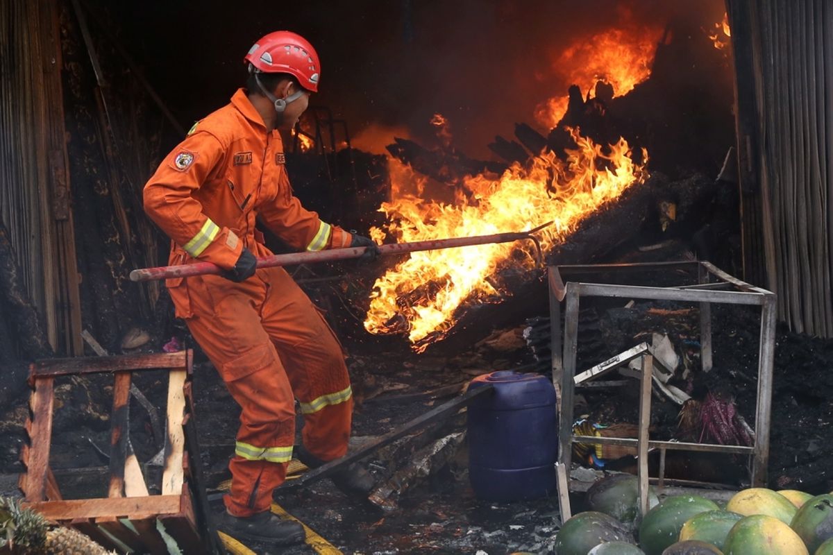 Aktivitas para petugas pemadam kebakaran saat memadamkan sebuah toko yang terbakar di Pasar Kebayoran Lama, Jakarta Selatan, Selasa (13/6/2017). Sebanyak 15 unit mobil damkar dikerahkan ke lokasi.