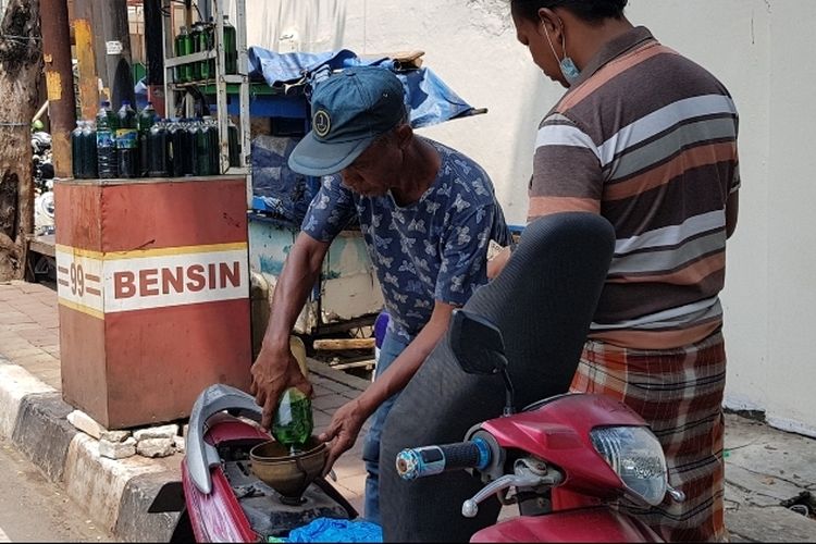 Siswo (55), seorang penjual bensin eceran di Jalan Sindang, Koja, Jakarta Utara, saat melayani pelanggannya yang membeli bahan bakar jenis Pertalite, Senin (4/4/2022).