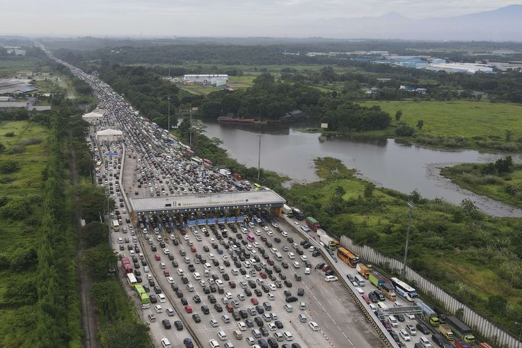 Foto udara sejumlah kendaraan antre melintasi Gerbang Tol Cikampek Utama, Kabupaten Purwakarta, Jawa Barat, Kamis (28/4/2022). Pada H-4 Lebaran 2022, ruas jalan tol Jakarta-Cikampek mengalami kepadatan volume kendaraan dan diperkirakan puncaknya pada H-3 Lebaran.