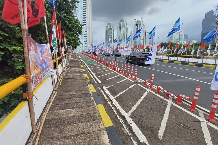Bendera partai terpasang di stick cone jalur sepeda, Jembatan Ciliwung Cokroaminoto dari arah Menteng, Jakarta Pusat, menuju Kuningan, Jakarta Selatan. Bahkan, ada beberapa bambu bekas bendera partai tergeletak di atas trotoar.