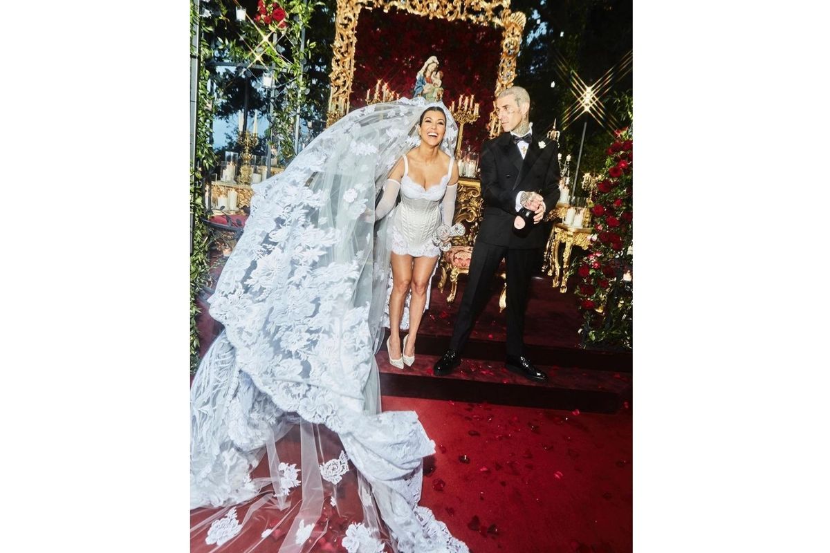 Kourtney Kardashian tengah berpose bersama Travis Barker usai keduanya melangsungkan pernikahan yang ketiga kalinya di Italia, Minggu (22/5/2022).
